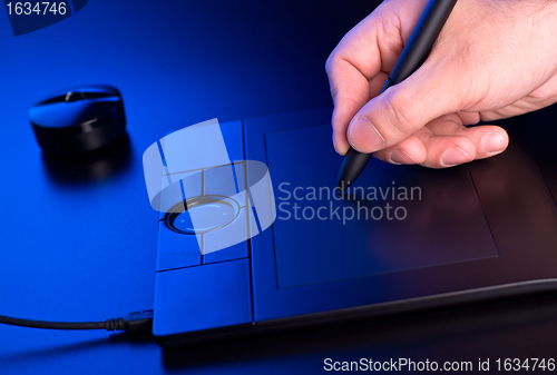 Image of man's hand draws on graphic tablet