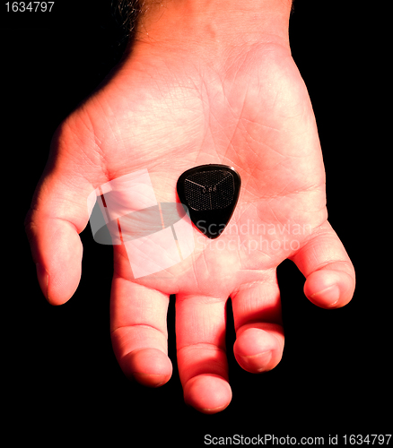 Image of guitar plectrum in hand