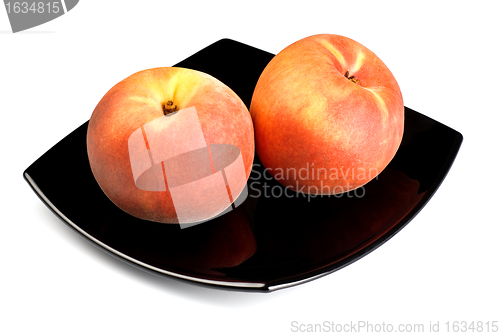 Image of red peaches on black dish