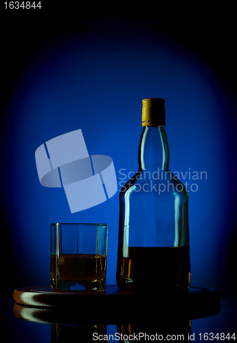 Image of whiskey bottle and glass on wooden tray