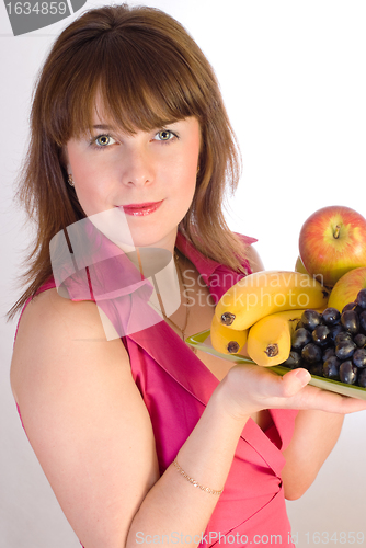 Image of beautiful smiling girl with dish of fruits