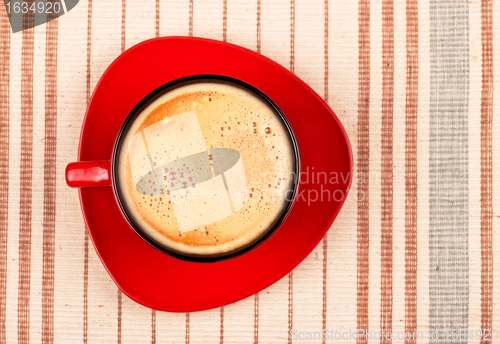 Image of red coffee cup on striped tablecloth