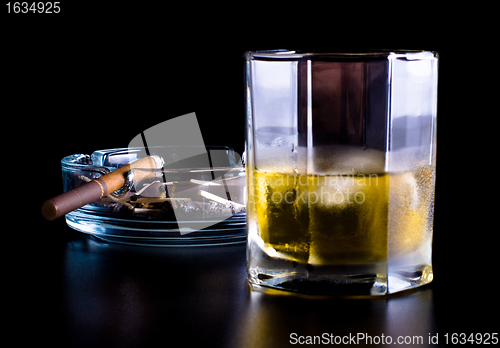 Image of ashtray full of butts and glass of whiskey