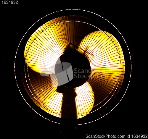 Image of big office fan in yellow light