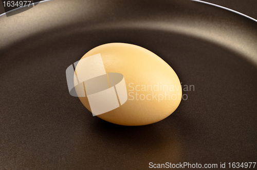 Image of brown egg on frying pan