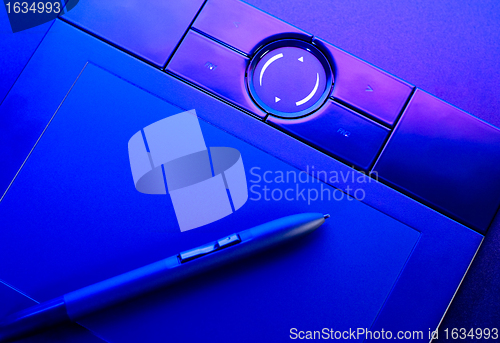 Image of drawing tablet with pen in blue light