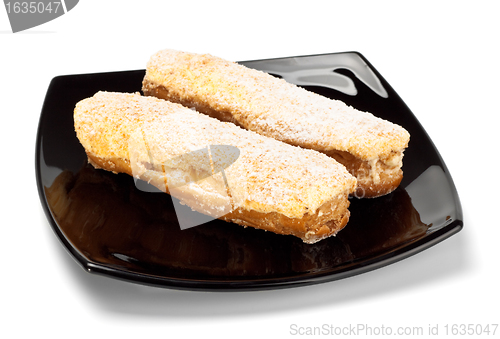 Image of two eclairs on black dish