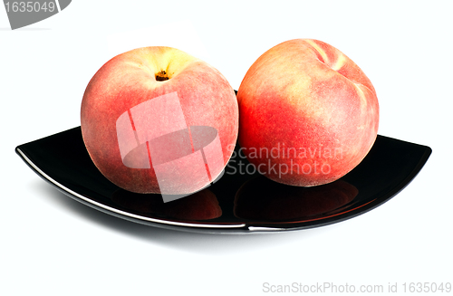 Image of red peaches on black dish