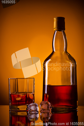 Image of whiskey bottle, ice and glass