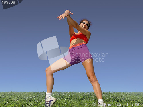 Image of Girl exercising outdoors on the grass