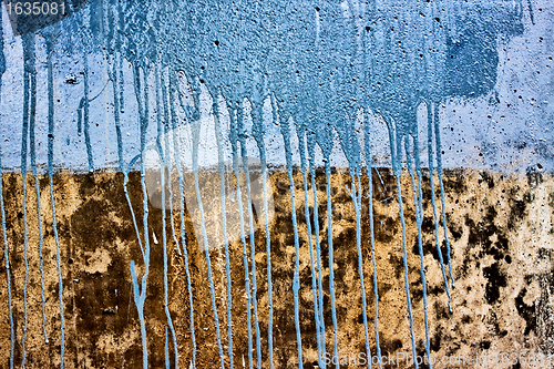 Image of concrete wall with drips of blue paint