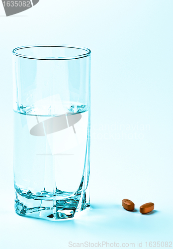 Image of two tablets and glass of water 