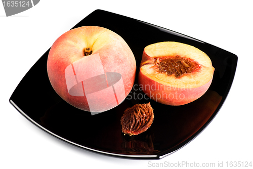 Image of red peaches with pip on black dish