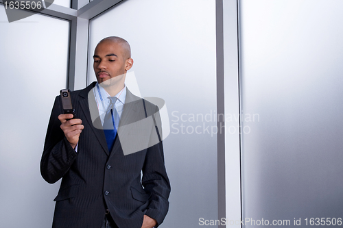 Image of Businessman dialing a number on his cell phone