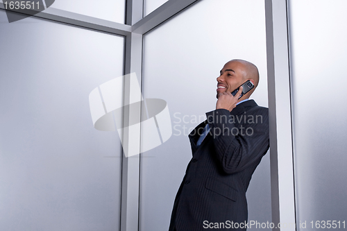 Image of Businessman talking on his cell phone and smiling