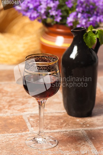 Image of Black jug for wine and a glass of red wine 