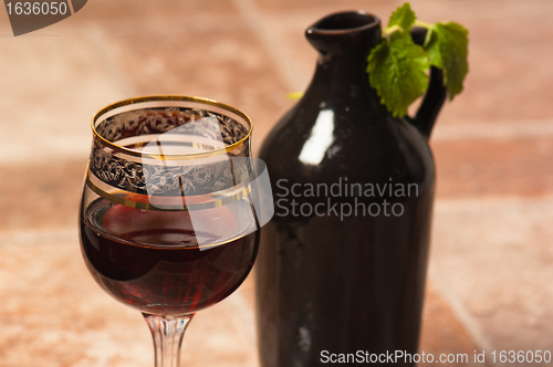 Image of Black jug for wine and a glass of red wine 