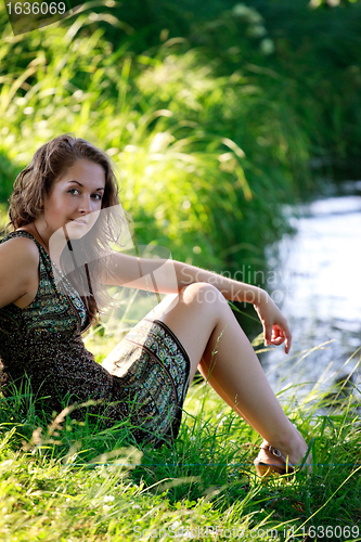 Image of woman sitting on riverside