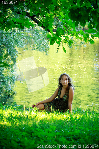 Image of woman sitting on riverside