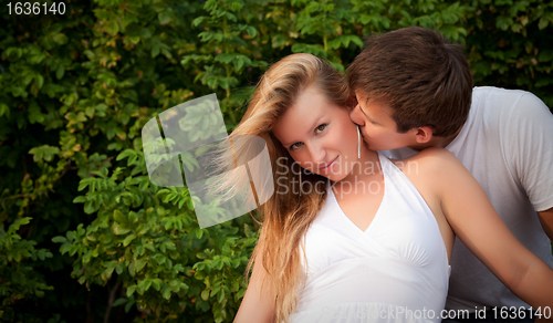 Image of man kiss sly girl in cheek