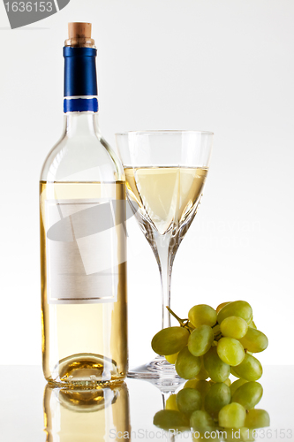 Image of bottle and glass of wine, grape bunch