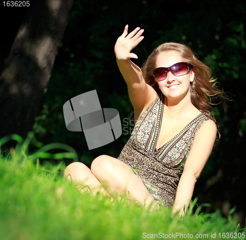Image of girl in sunglasses sitting in grass