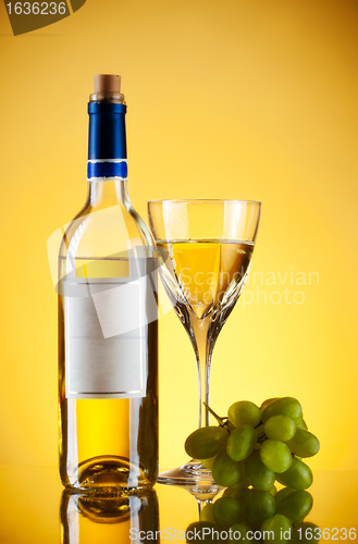 Image of bottle and glass of wine, grape bunch