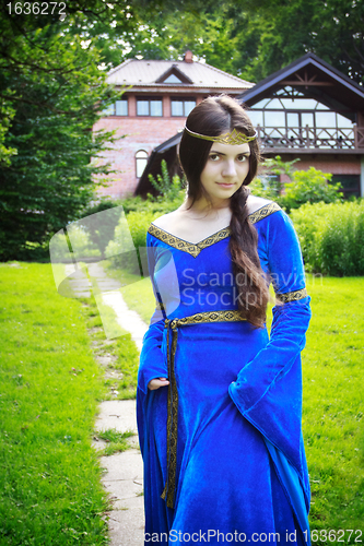 Image of princess stand against house in forest