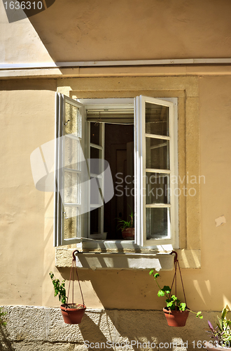 Image of opened window with flowerpots