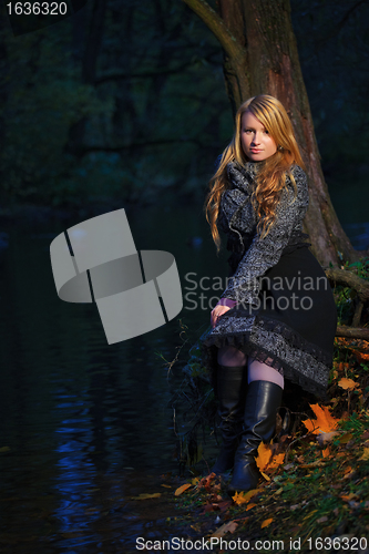 Image of girl sitting on the edge of pond