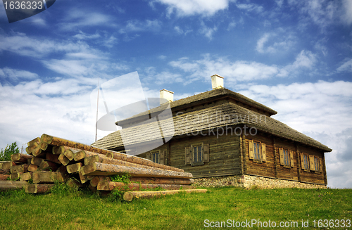 Image of wooden cottage on green hill