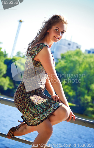 Image of beautyful woman sitting on parapet