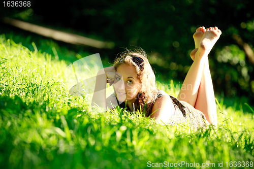 Image of beautiful girl laying on sunny meadow