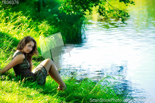 Image of woman sitting on shore