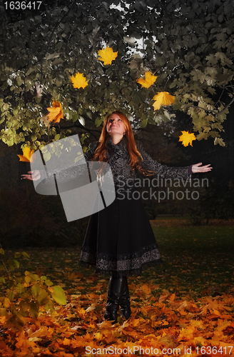 Image of girl juggling leaves in autumn park