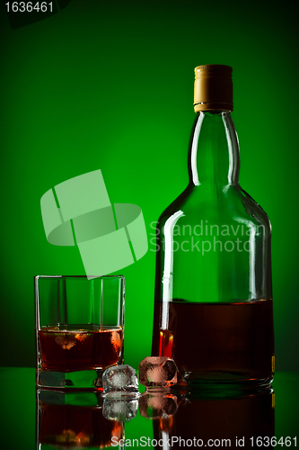 Image of whiskey bottle, ice and glass