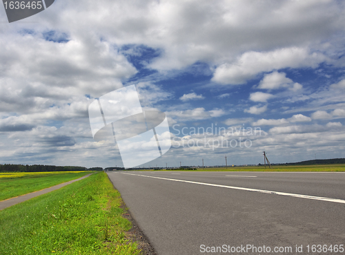 Image of highway under blue cloudy sky