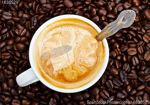 Image of espresso cup in coffee beans