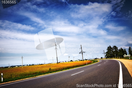 Image of highway under blue cloudy sky