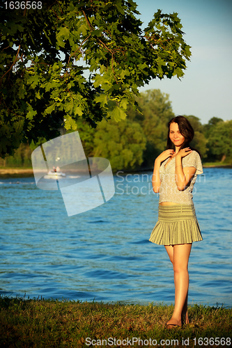 Image of cute girl on river coast