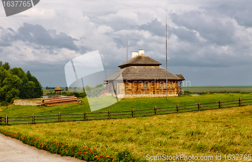 Image of wooden cottage on green hill