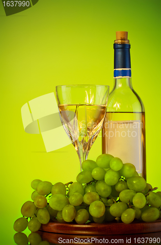 Image of bottle and glass of wine, grape bunch