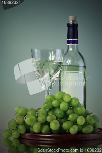 Image of bottle and glass of wine, grape bunch