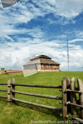 Image of wooden cottage on green hill