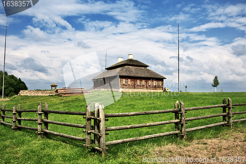 Image of wooden cottage on green hill