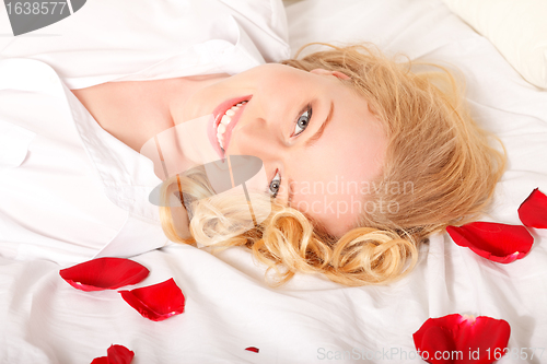 Image of Happy Woman In Bed With Rose Petals