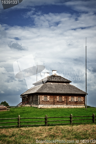 Image of wooden cottage on green hill