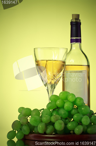 Image of bottle and glass of wine, grape bunch