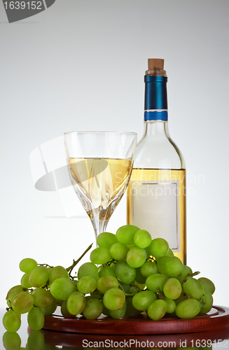 Image of bottle and glass of wine, grape bunch