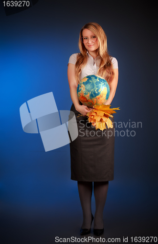 Image of pretty teacher with globe and maple leaves